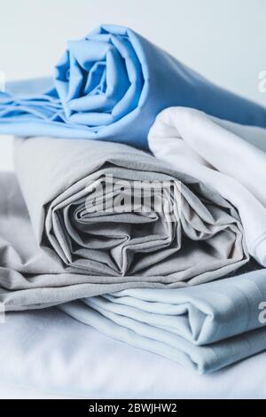 Stack of clean bed sheets on table Stock Photo
