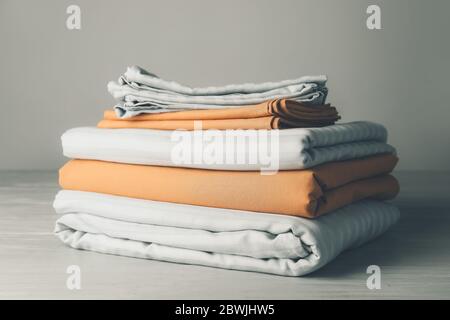 Stack of clean bed sheets on table Stock Photo