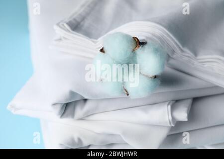 Stack of clean bed sheets on color background, closeup Stock Photo