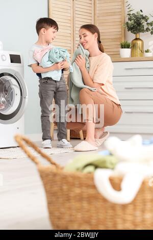 Young woman with her little son doing laundry at home Stock Photo