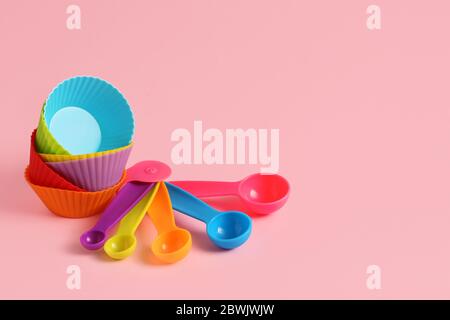 Muffin baking cups with utensils on color background Stock Photo