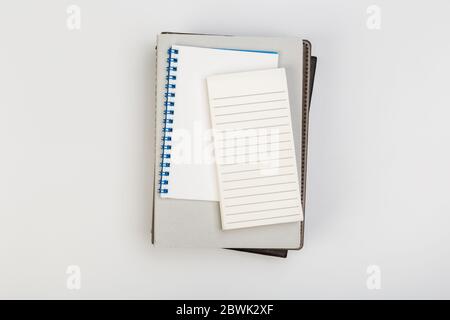 a stack of several spiral school notebooks lies on a white table with a pencil, office concept Stock Photo