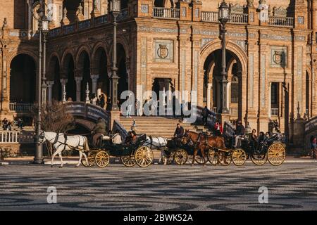 Seville, Spain - January 17, 2020: Horse-drawn carriages city tour on Plaza de España, a plaza in the Parque de María Luisa, in Seville, Spain, built Stock Photo