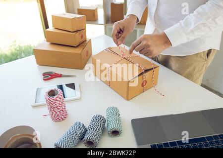 Young asian teenage product owners are packing small business packaging products in boxes prepared for shipping. Stock Photo