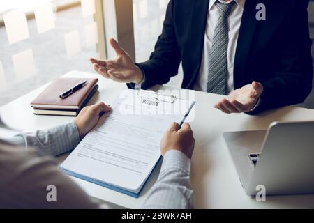 Asian young adult sitting at desk across from manager being interviewed job interview in business room. Stock Photo