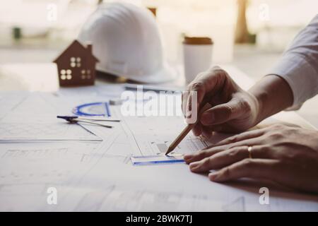 The partnership engineering man or co-workers working on a project and discussing together with looking at blueprint paperwork. Stock Photo