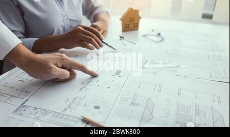 Engineering man showing blueprint detail for people buying house. Stock Photo