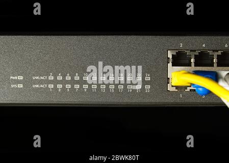 Network switch and ethernet cable in rack cabinet. Network connection technology thrue cat6 and cat5 wires. Network switch and cables. Stock Photo