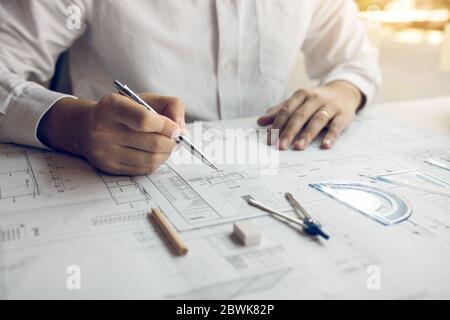 Engineers are designing working on blueprints and analyzing the structure of the project. Stock Photo