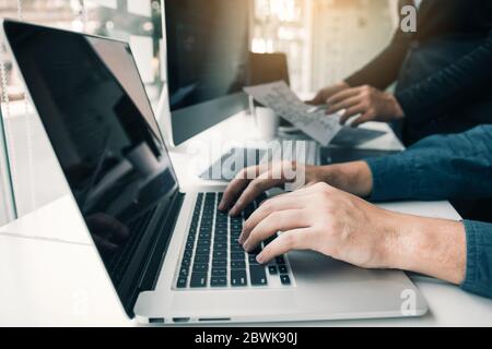 Two partnerships developing programming and coding technologies working on laptop and analyzing together. Stock Photo