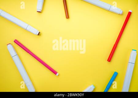 Colored markers and felt-tip pens on a yellow background. Back to school. Stock Photo