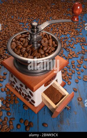 manual coffee grinder with coffee beans on a blue wooden background Stock Photo