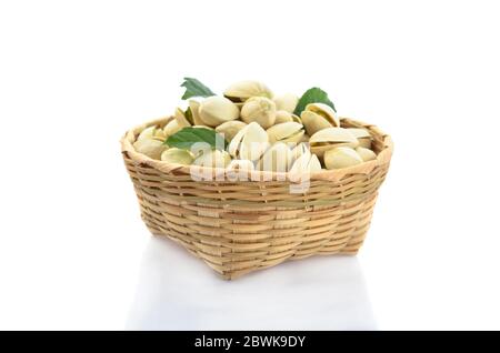 Pistachio and green leaf in bamboo basket isolated on white background Stock Photo