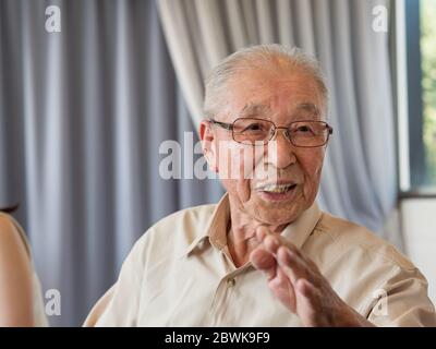 An old man talking animatedly at a family event Stock Photo