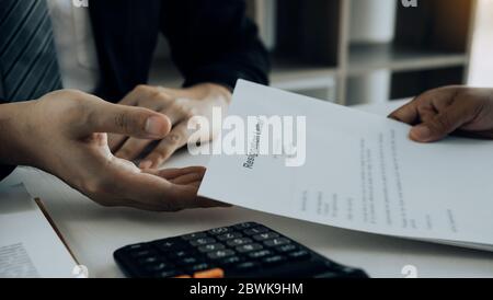 Woman employee takes the handle to the resignation envelope while being handed over to the female manager. Stock Photo