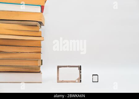 Stack of books, hard disk drive and memory card, improving technology. Storage data, compressed information, digital versus analog concept Stock Photo