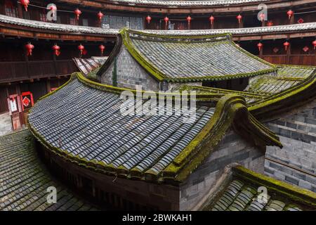 View into the inner courtyard of a Fujian Tulou: small brick buildings with moss-covered roof tiles. Stock Photo