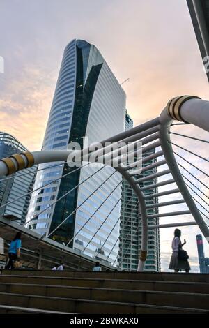 People walking at Chong Nonsi skywalk in the evening to go Home,with high buildingtransportation in heart of Bangkok, Thailand Stock Photo