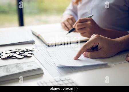 Two asian couples and men and women are together analyzing expenses or finances in deposit accounts and daily income sources with an savings economica Stock Photo