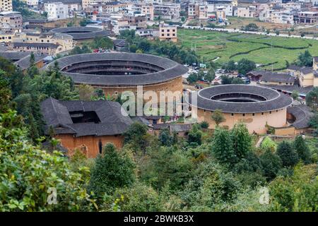 High angle view of three Fujian Tulou. The Chinese expression of the traditional houses is 福建土楼 - literally translated 'Fujian earthen buildings'. Stock Photo