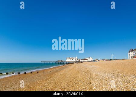 The pier and stony shingle beach on the seafront at Bognor Regis, a seaside town in West Sussex, south coast England on a sunny day with blue sky Stock Photo
