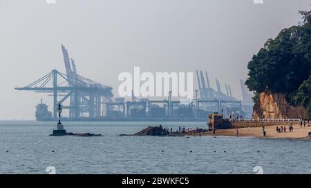 View on the port of Xiamen (Free Trade Zone Haicang District) with a ship and cranes. Symbol for international trade, economy, shipping, cargo. Stock Photo