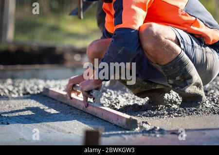 Pouring and leveling a new concrete slab for a residential house under construction in Melbourne Australia Stock Photo