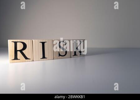 The word Risk was written with wooden cubes. Stock Photo