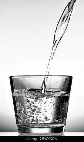 Pouring hot water into into a cup on a black background, Stock image