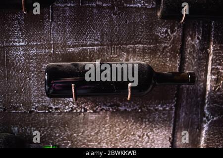Old, ancient wine collection and dusty wine bottles in an underground cellar Stock Photo