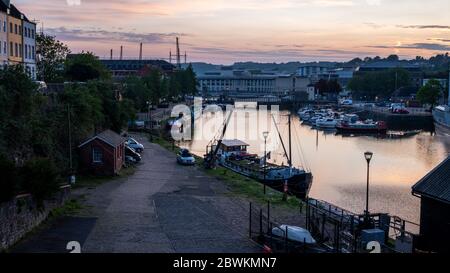 Bristol, England, UK - April 11, 2020: The sun sets over Bristol's Floating Harbour, and houseboats moored along Redcliffe Quay and Mud Dock, as viewe Stock Photo