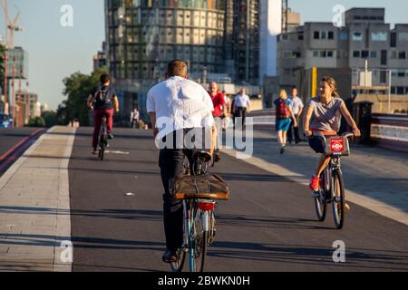 London, England, UK - July 19, 2016: Commuter cyclists ride across Blackfriars Bridge on the newly opened Cycle Superhighway 6. Stock Photo