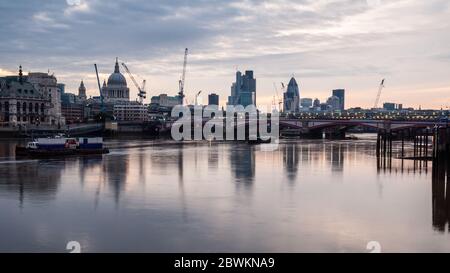 London, England, UK - June 15, 2011: The sun rises over the River Thames, Blackfriars Bridge and the City of London skyline. Stock Photo