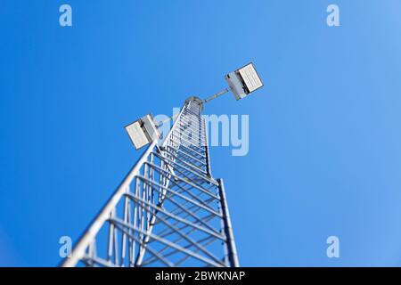 big and high floodlights against blue sky Stock Photo
