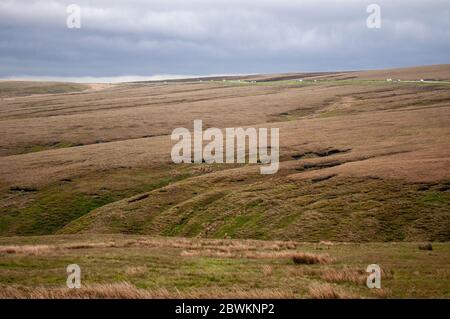 Traffic travels on the A628 Woodhead Pass road over Gallows Moss moor on the Pennine hills of the South Yorkshire Peak District. Stock Photo