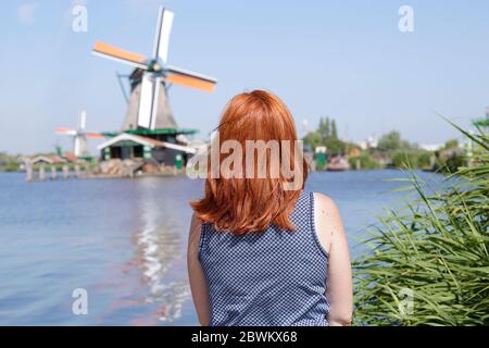 Woman enjoying the view of the windmills of Zaanse Schans, The Netherlands Stock Photo