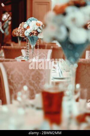 Beautifully decorated of luxury wedding banquet at restaurant. Bouquet of flowers on served tables. Life event, wedding or birthday reception Stock Photo