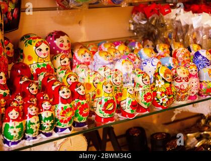 Matryoshka is a national Russian souvenir. Russian wooden dolls matryoshka on display of colorful traditional Russian matryoshka in gift shop. Stock Photo