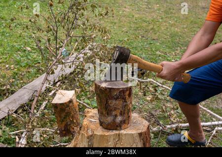 Lumberjack chopping wood. ax stuck in stump. Travel, adventure, camping gear. Stock Photo