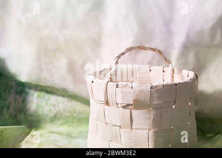 Empty rounded wooden basket on blur light green background. Stock Photo
