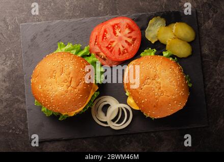 Tasty grilled home made burgers with beef, tomato, cheese, cucumber and lettuce. Top view with copy space. Stock Photo