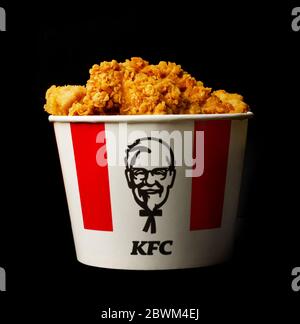 Moscow, Russia - November 16, 2019: A lots of KFC chicken hot wings or strips in bucket of KFC (Kentucky Fried Chicken) fast food.
