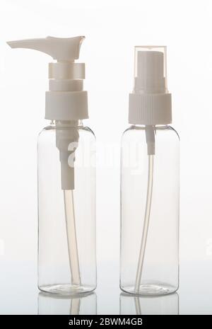 Empty transparent cosmetics bottles isolated on white background. Plastic or glass clear blank flasks with dispenser or lid. Vertical photo. Stock Photo