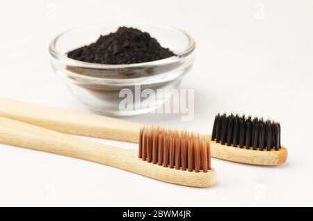 Bamboo toothbrush with black charcoal toothpaste powder on a white background Stock Photo