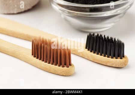 Bamboo toothbrush with black charcoal toothpaste powder on a white background Stock Photo