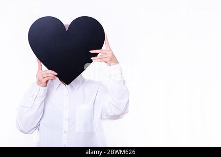 Woman holding black figured chalkboard infront of face. Photo on the white background. Stock Photo