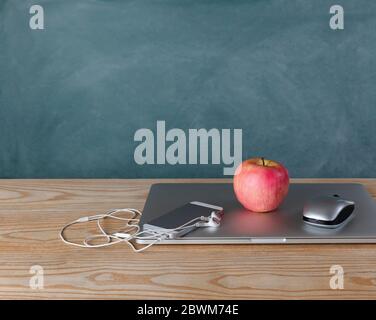 Back to school concept with basic modern technology on desktop with chalkboard in background Stock Photo
