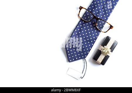 Blue tie, wrapped gift box, eyeglasses and gift tag on white background. Happy father's day, business present concept. Mock up, greeting card, symbol Stock Photo