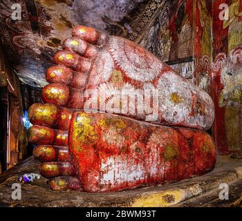 DAMBULLA, SRI LANKA - APRIL 22, 2016: View of feet of lying Buddha Statue inside cave Golden temple in Dambulla, Sri Lanka. It is a UNESCO World Herit Stock Photo