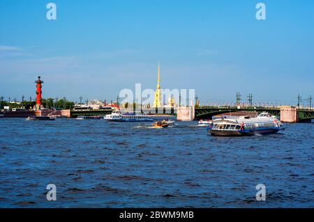 Saint Petersburg, Russia. Touristic boats with people going down the Neva river in front of Peter and Paul fortress. Summer day with cloudy blue sky Stock Photo